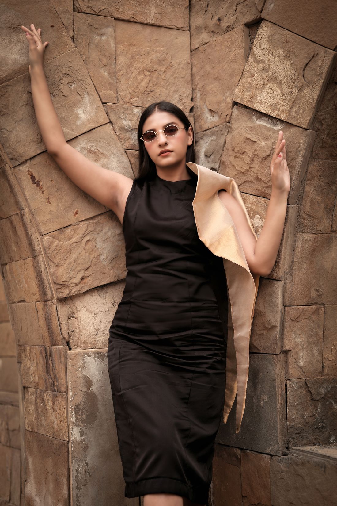 Fashion model posing under a stone archway
